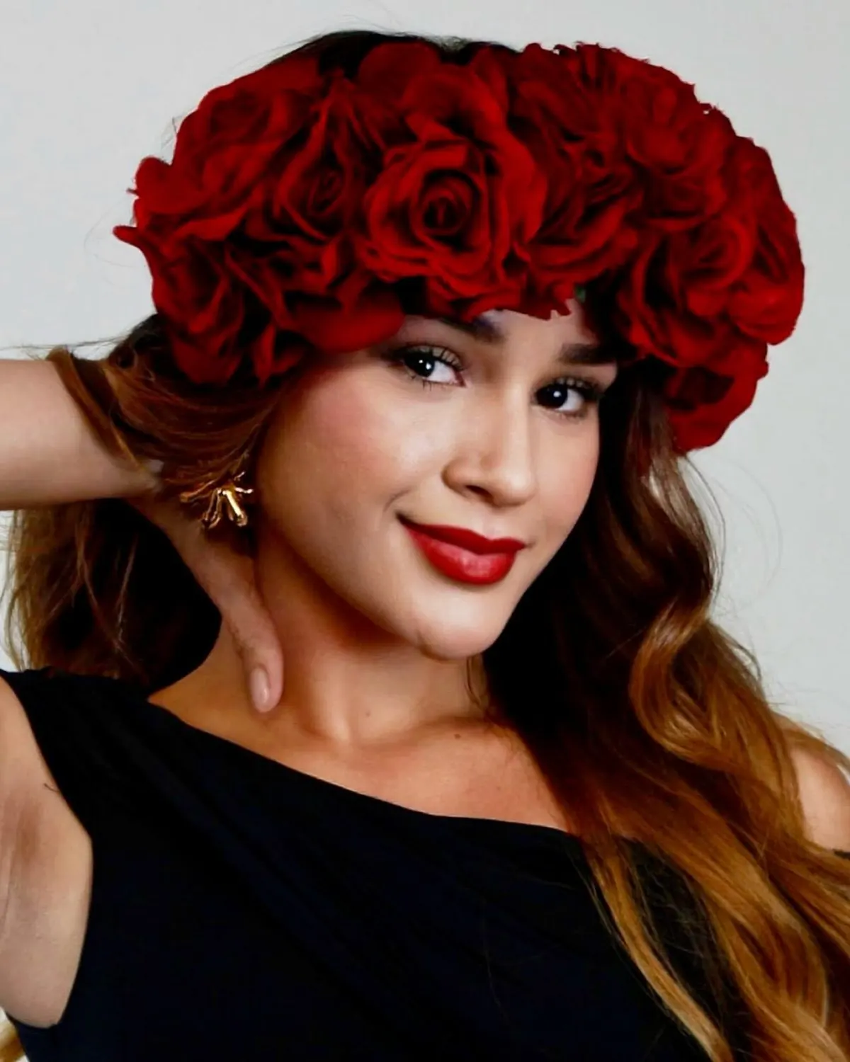Candidata con corona de rosas rojas sonríe a la cámara
