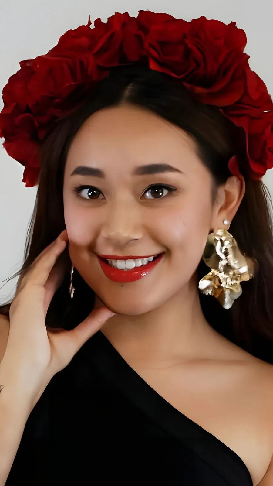 Candidata con corona de rosas rojas y aretes dorados